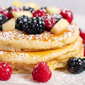 Фото вкусные оладьи без яиц с фруктами на сковороде